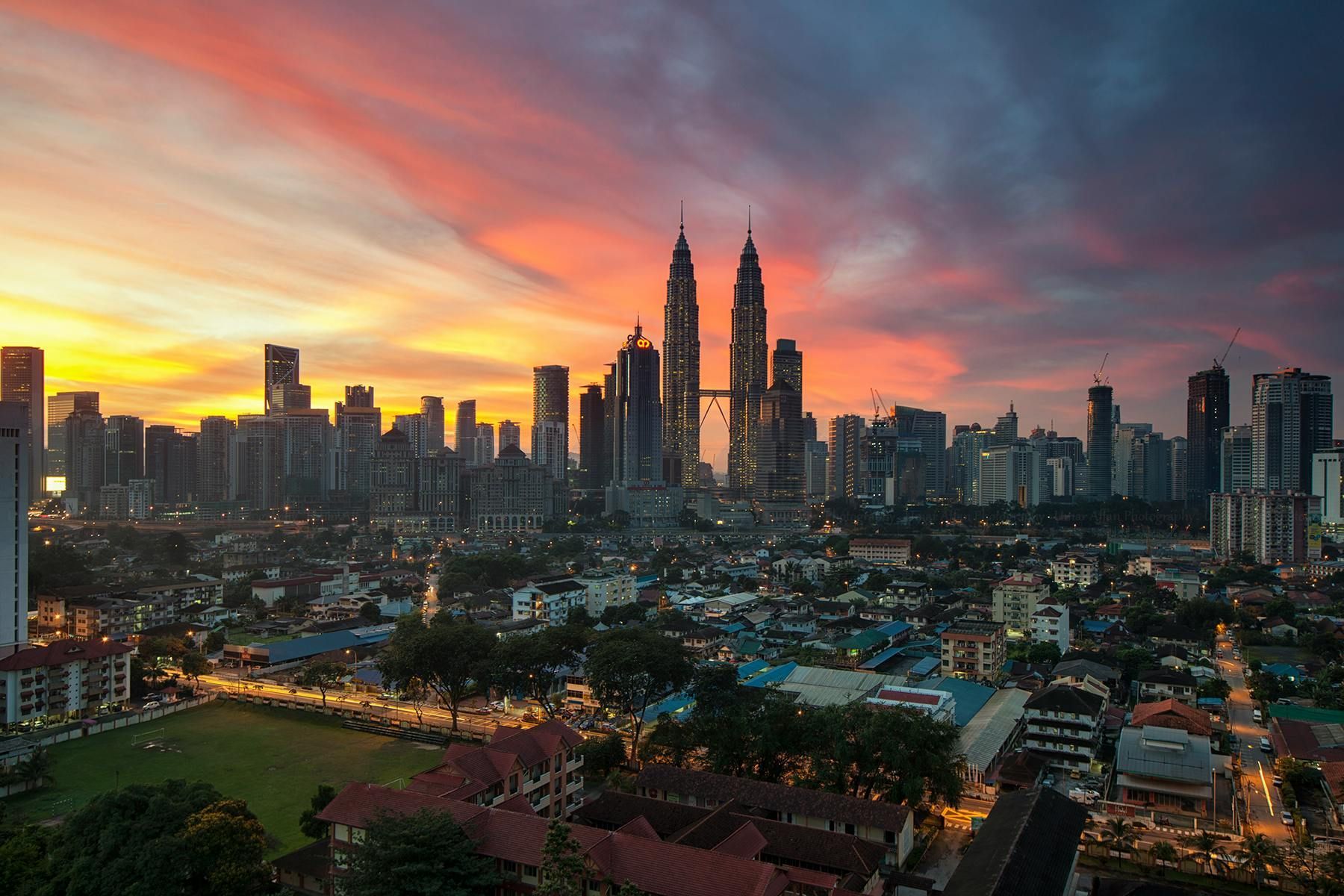Sunset over Kuala Lumpur skyline with the Petronas Twin Towers and colorful clouds