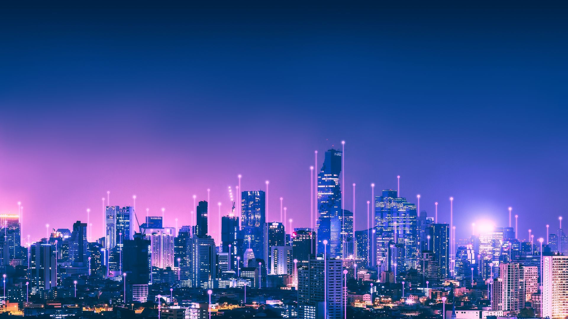 City skyline at night with glowing vertical lines, lit with purple and blue hues.