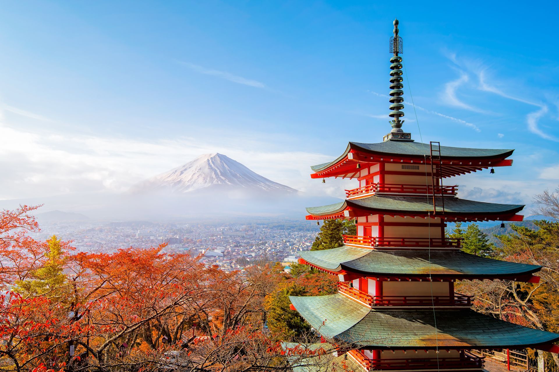 Pagoda with Mount Fuji in the background, autumn foliage, blue sky.