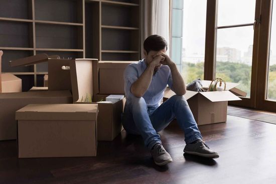 A Man Is Sitting On The Floor In A Room Surrounded By Cardboard Boxes – Independence, MO - Mary Hargrave