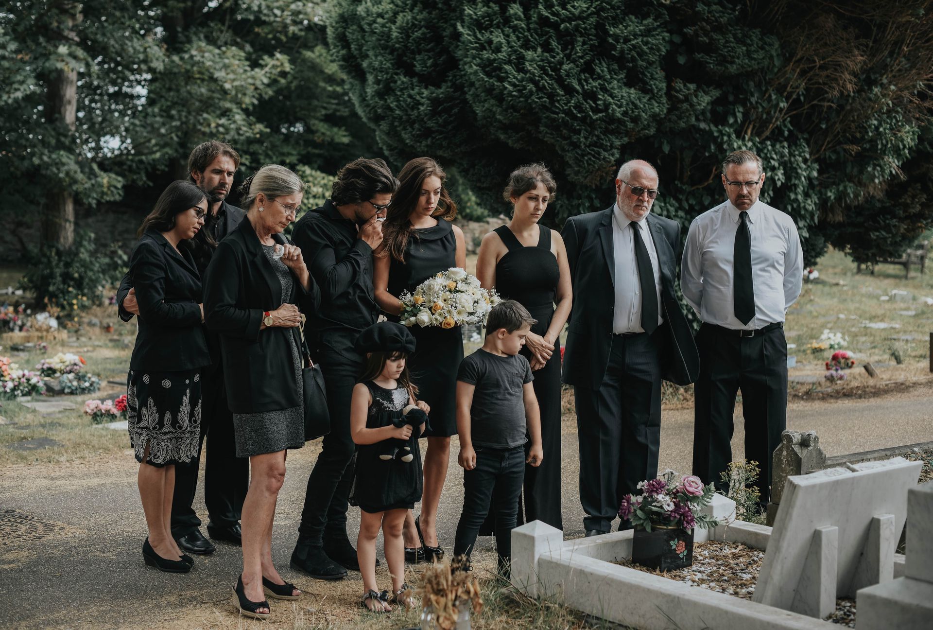 family paying their respect at a tombstone