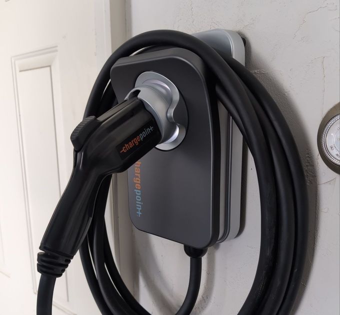 A charging cord is attached to a wall charger