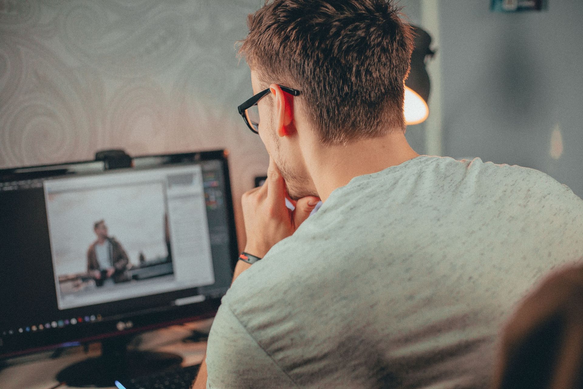 Person at a desk looking at a computer monitor during a video call