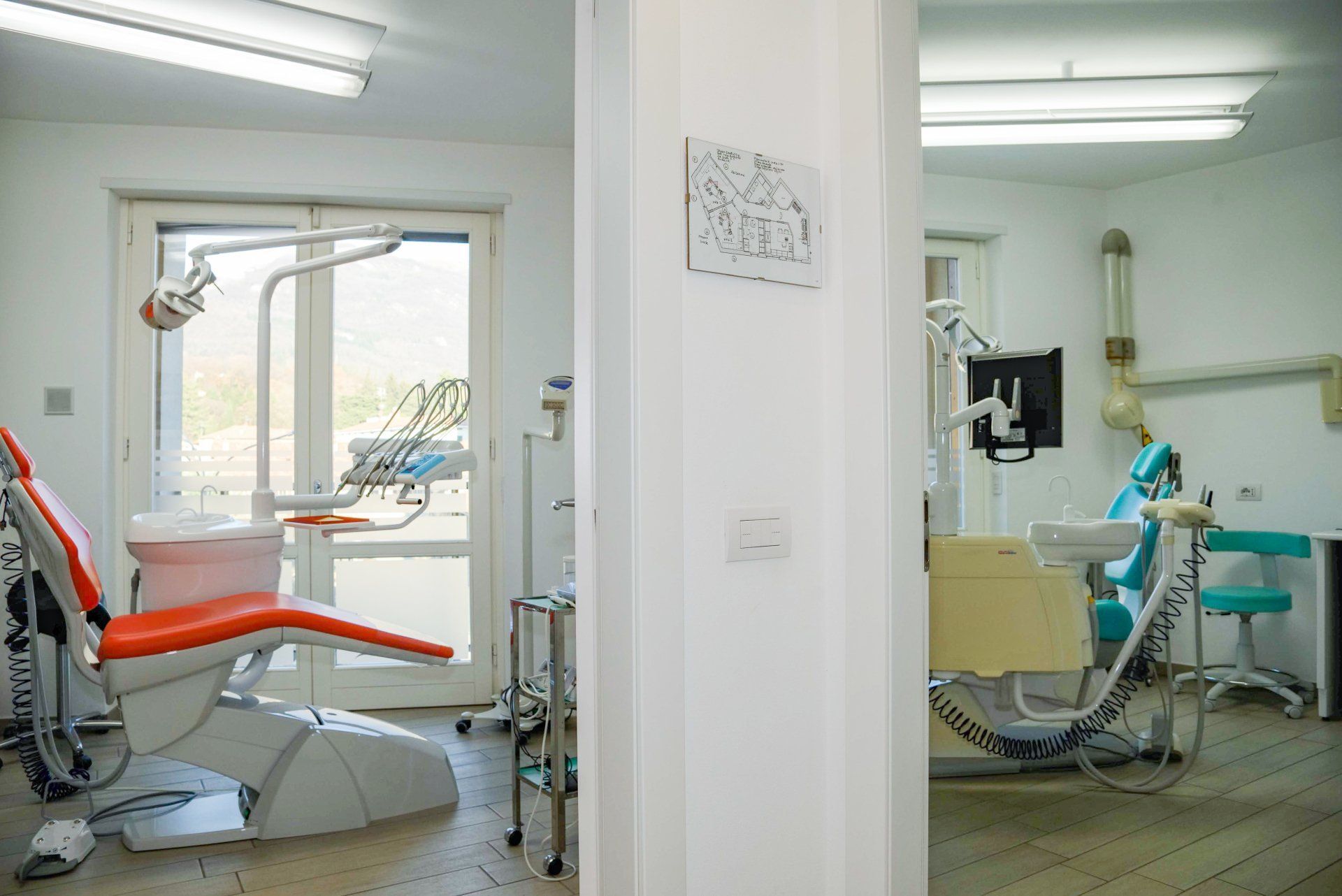 Studio dentistico con due poltrone per i trattamenti e attrezzature in luminose sale visita.