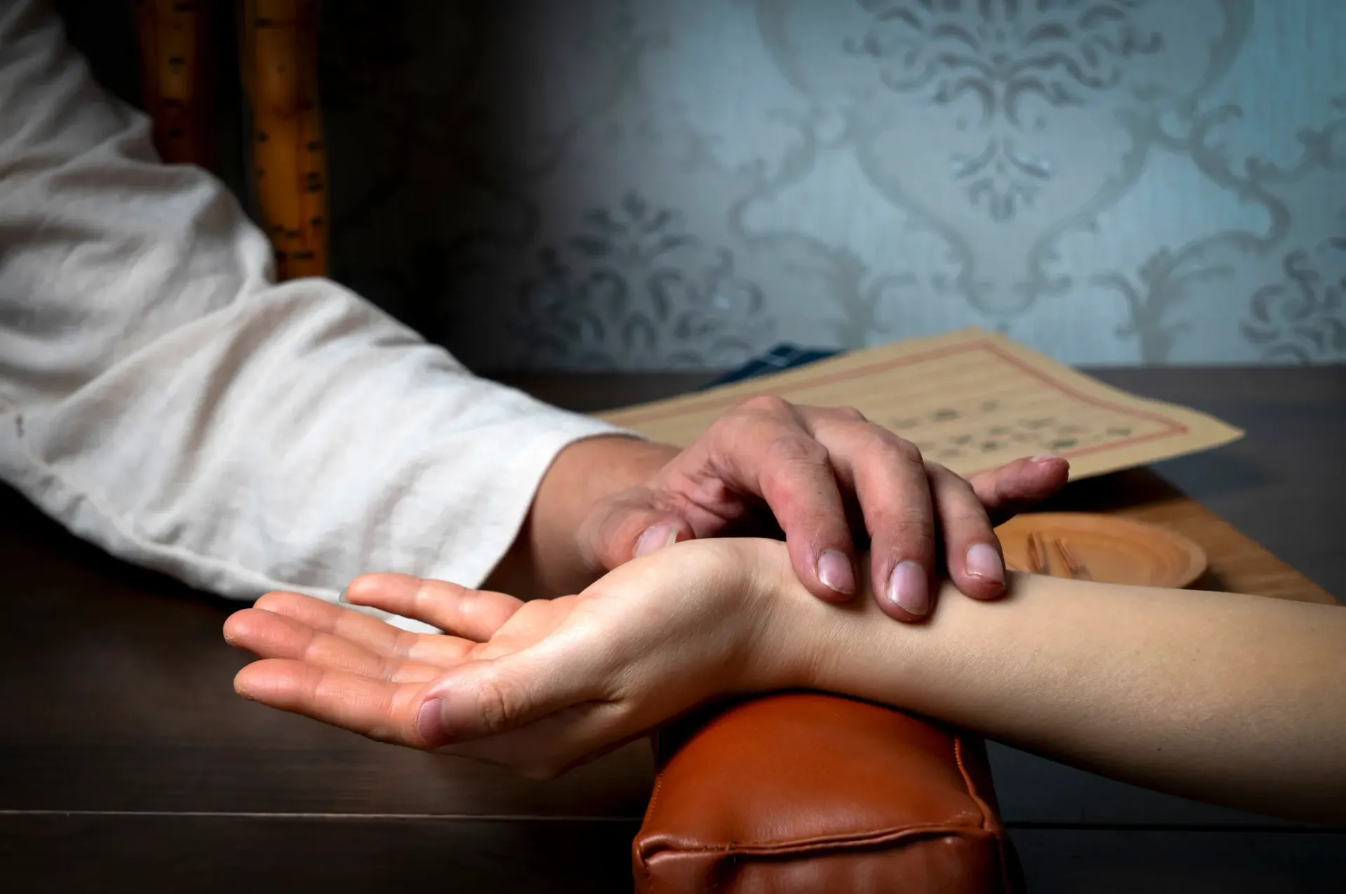 traditional chinese medicine practitioner taking a clients pulse. 
