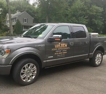 Gray pickup truck with “Golden” business lettering parked on a residential street