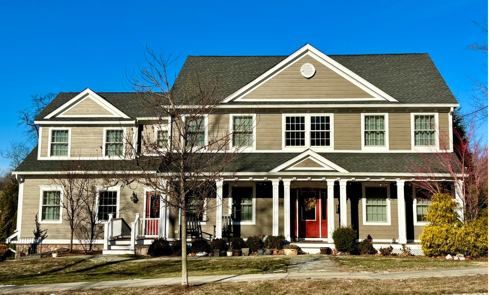 A large house with a green roof and a red door