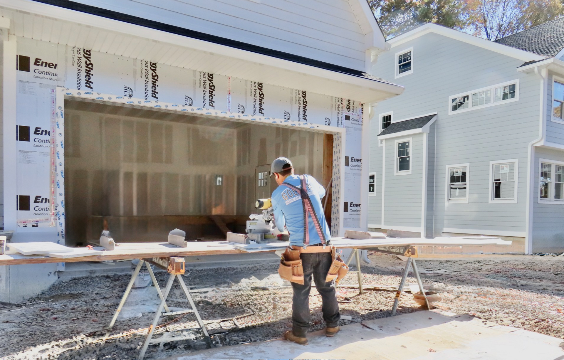 Construction worker measuring outside a modern house under renovation