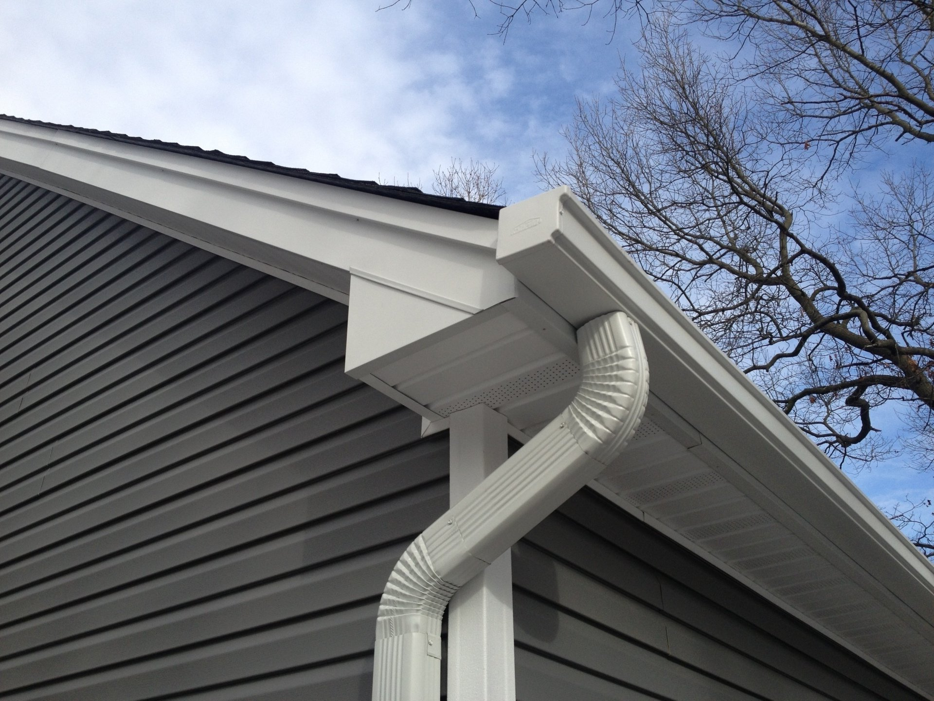 A white gutter on the side of a house