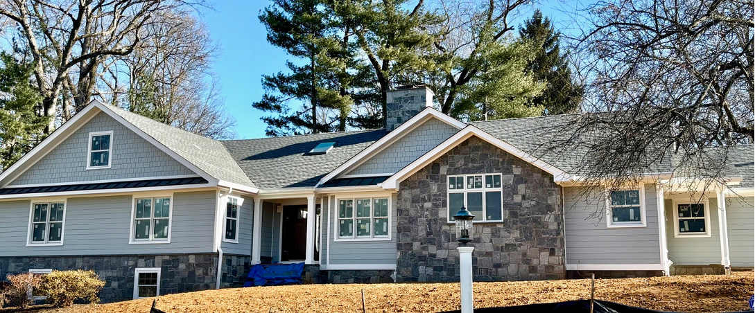 A large house with a lot of windows and trees in the background.