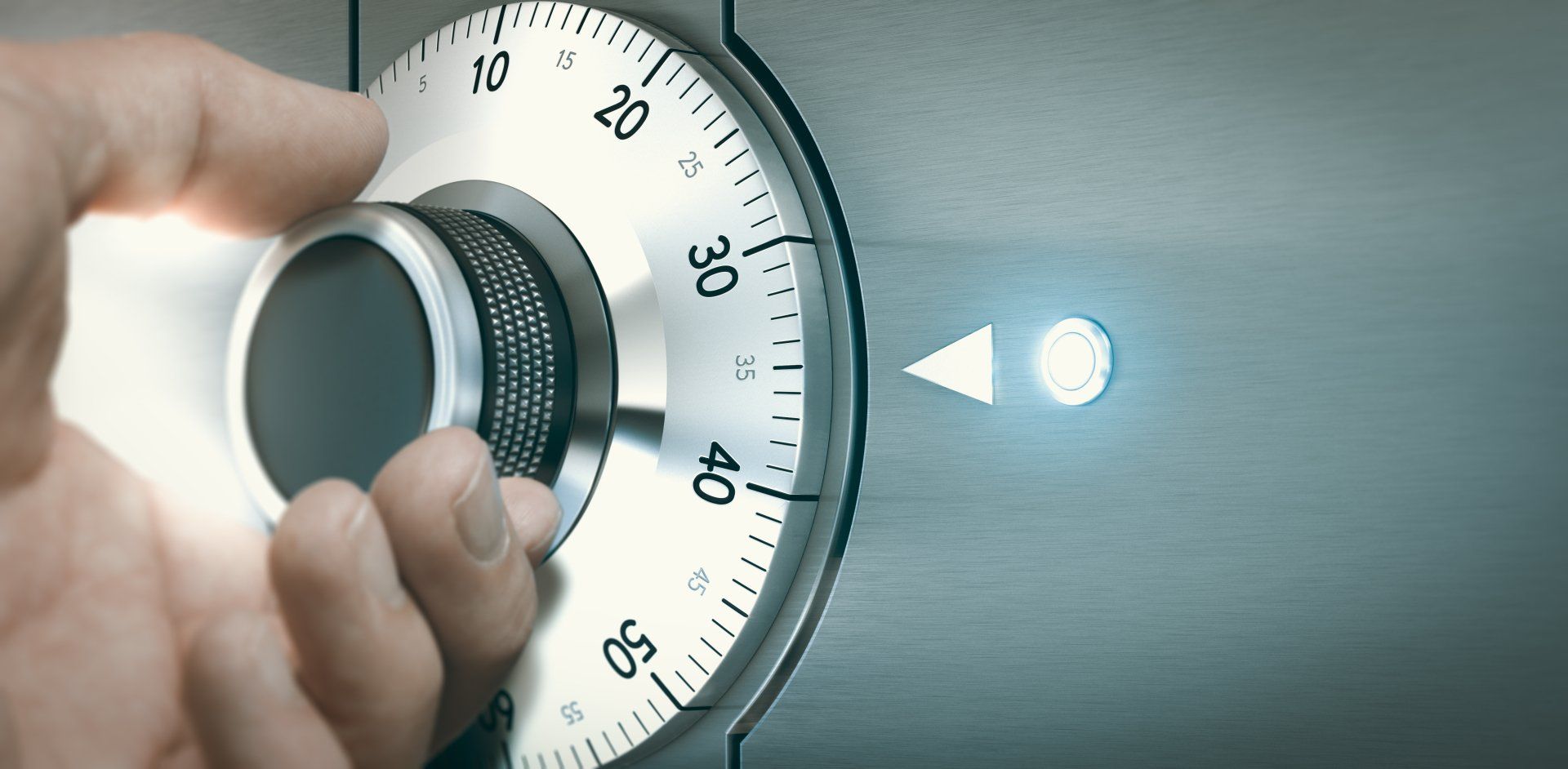 Close up of a hand unlocking a safe deposit box by turning a knob with numbers