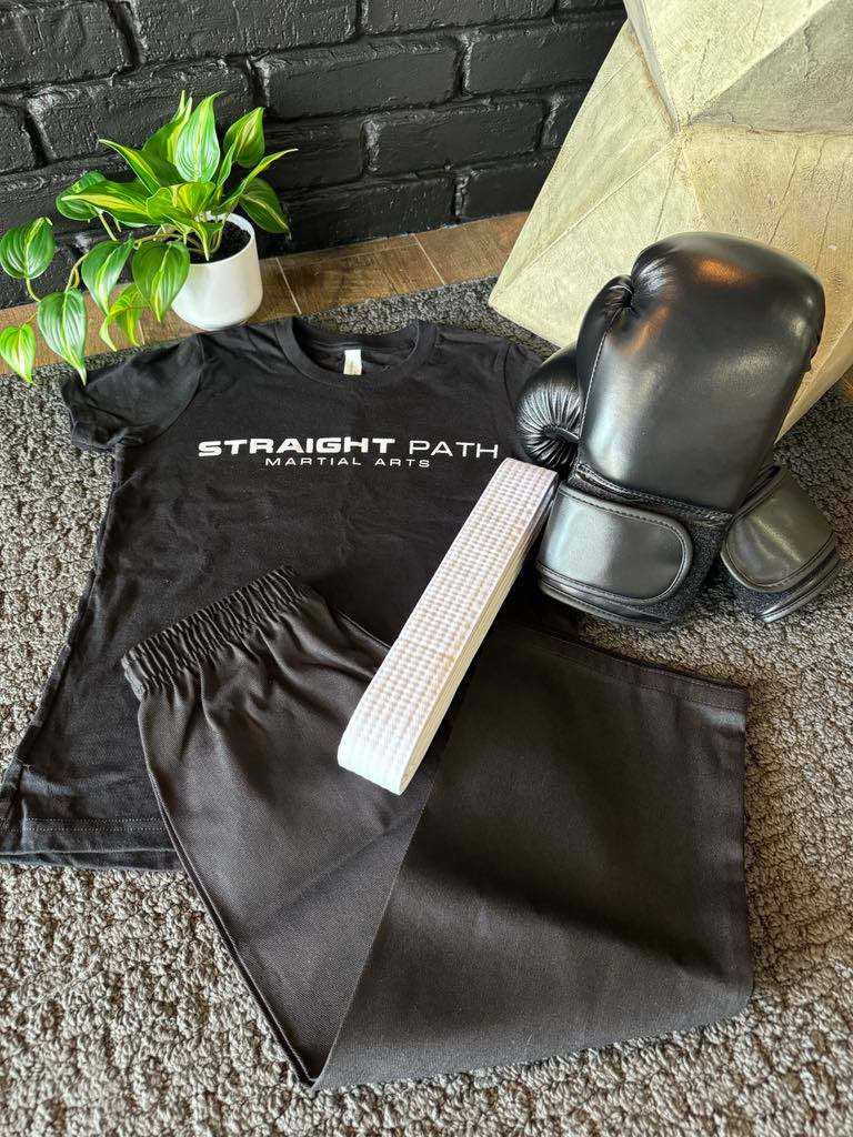 a white karate uniform and black boxing gloves on a white background .