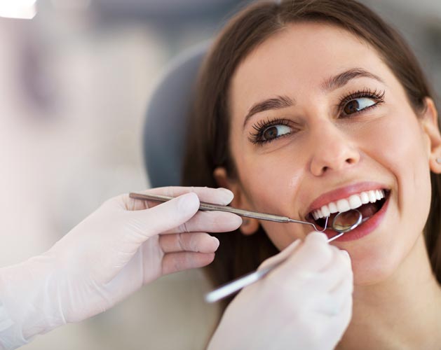 Woman having teeth examined at dentists — Statesville, NC — James J Flerra, DDS PA Woman having teeth examined at dentists — Statesville, NC — James J Flerra, DDS PA