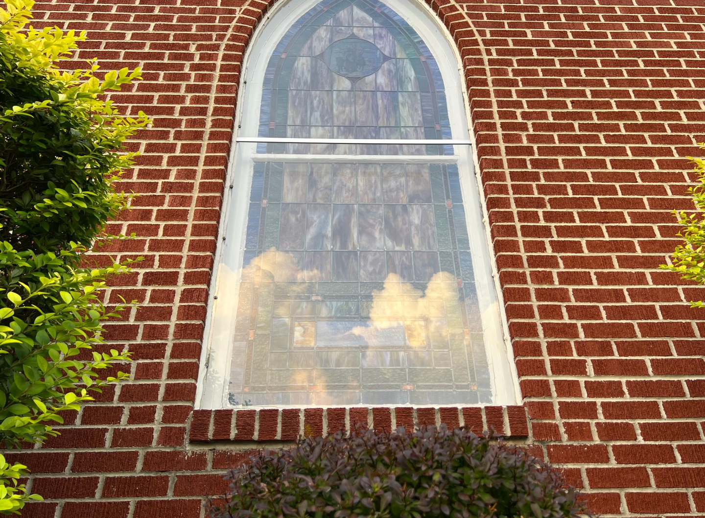 Our stained glass window with a reflection of clouds.