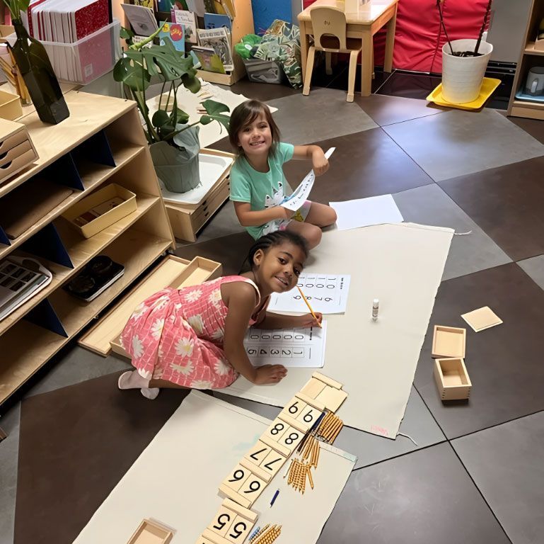Two Montessori children working on the Tens Board math material.