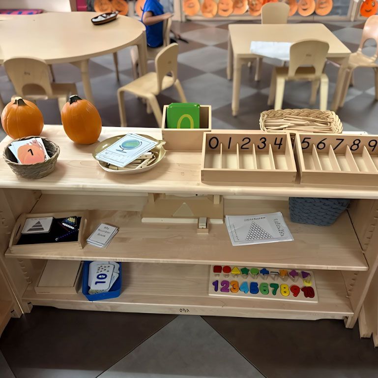 Montessori math shelf with Spindle Boxes and seasonal decor.