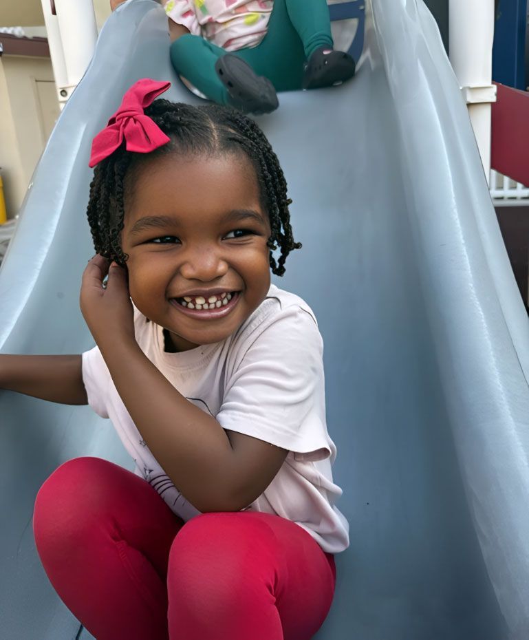 Montessori children on a playground slide