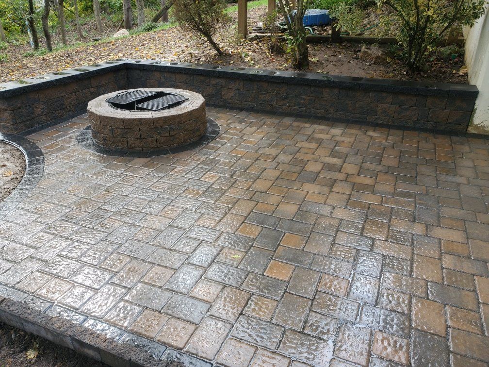 A fire pit is sitting on top of a brick patio.