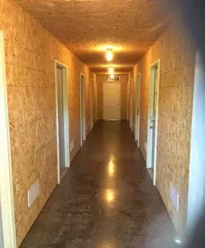 A long hallway with a lot of doors and a light on the ceiling.