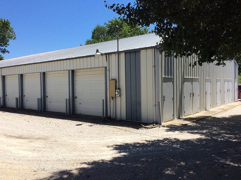 A building with a lot of garage doors and a tree in front of it