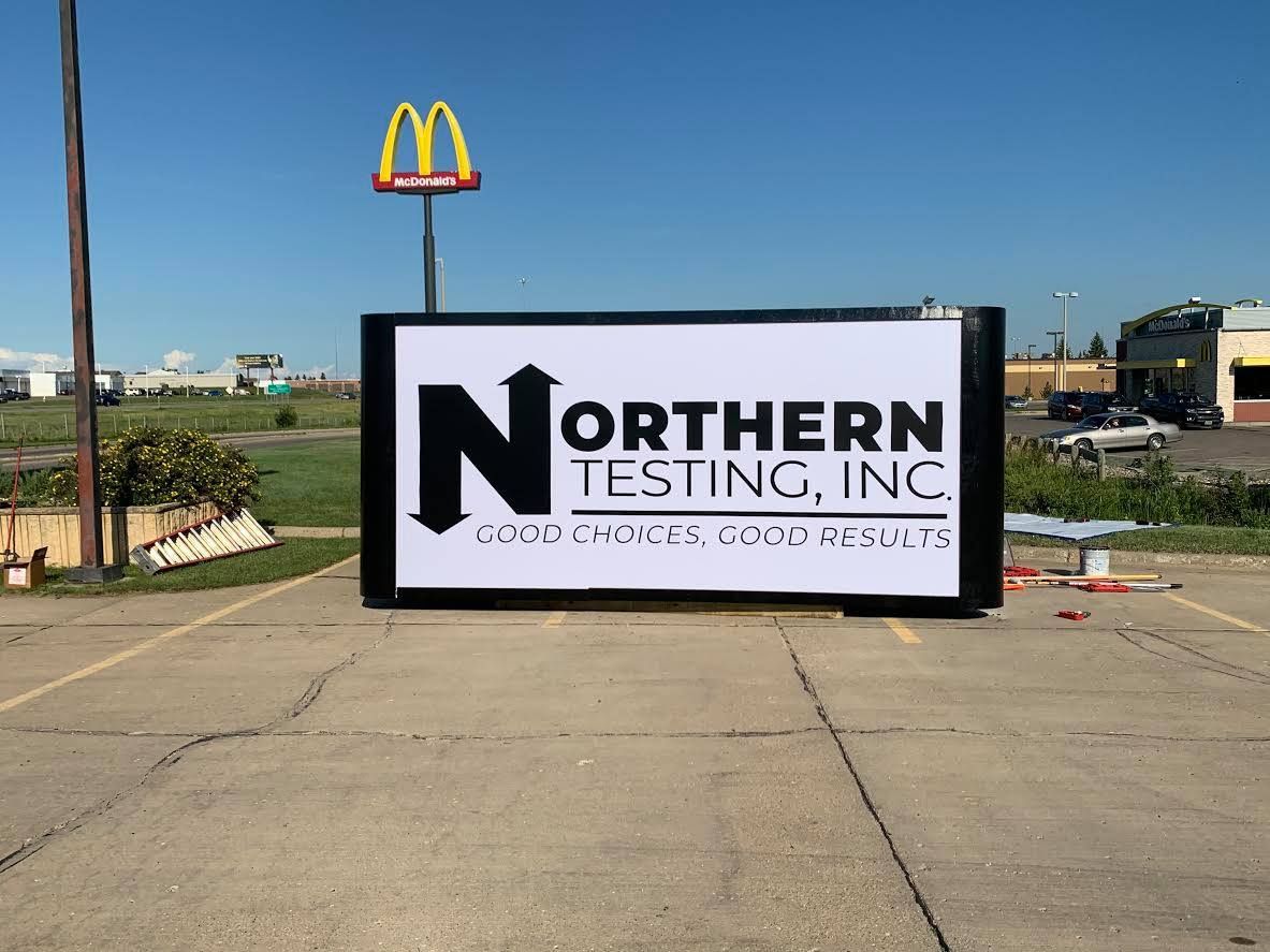 Northern Testing, Inc. sign in a parking lot with a McDonald’s sign in the background