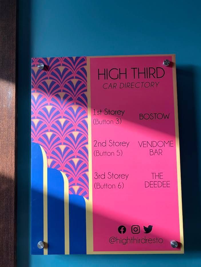 Pink and blue beauty salon price board on a wall with social media icons at the bottom