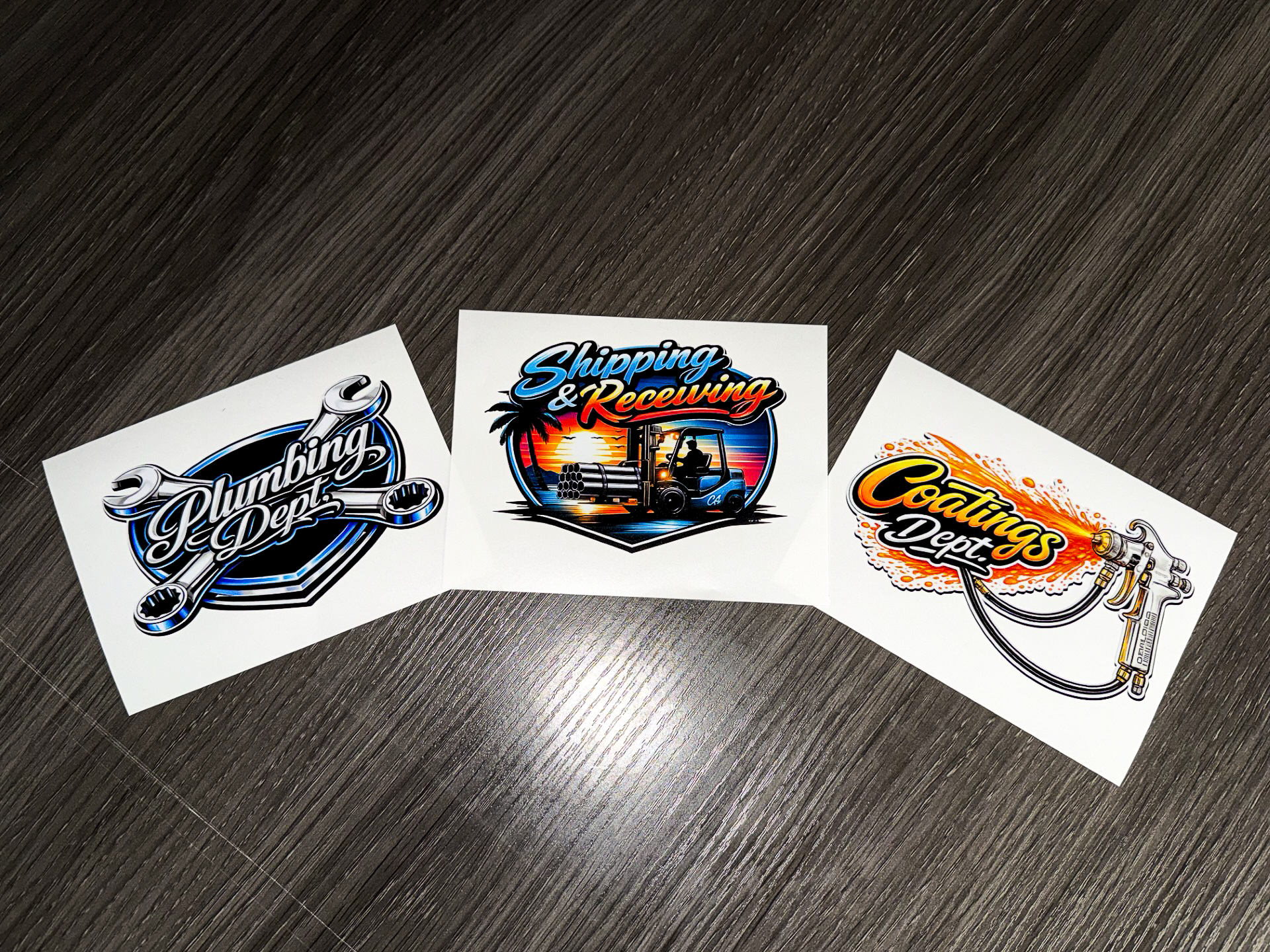 Three colorful racing-themed sticker logos on a dark surface