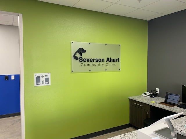 Severson Ahrt Community Clinic sign on a lime-green wall beside a front desk and computer in a lobby
