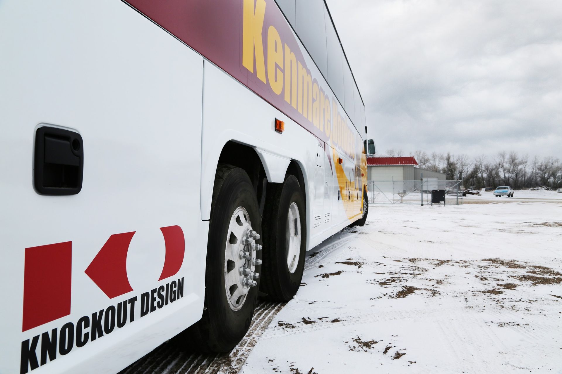 Knockout Design racing trailer parked on a snowy lot, viewed from the side.