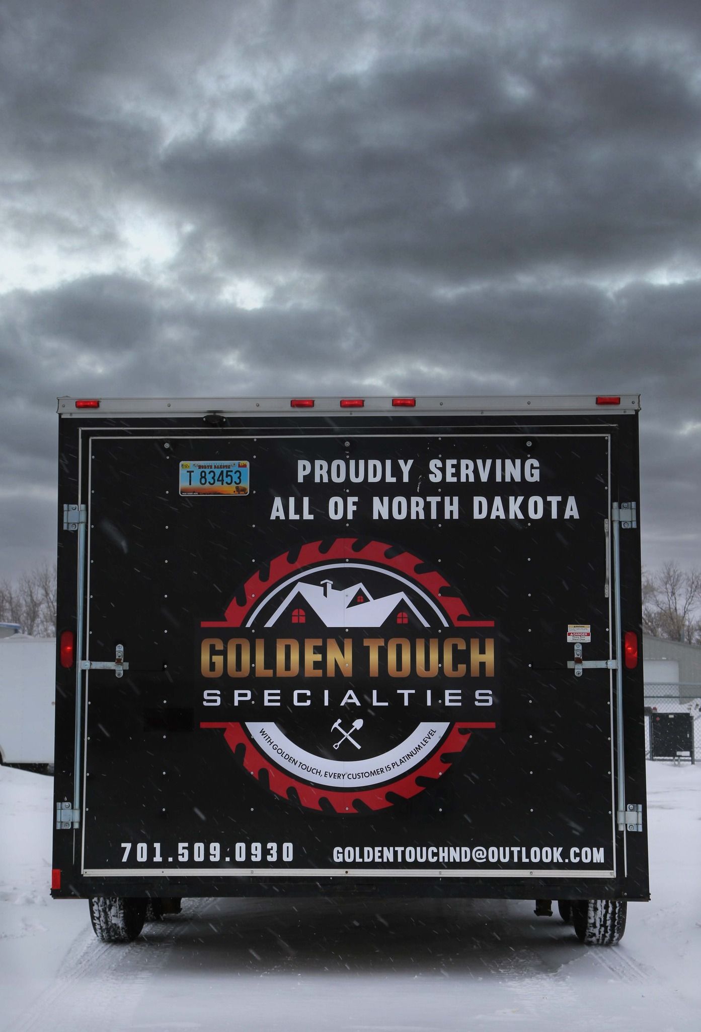 Black truck trailer with “Golden Touch Specialties” logo under cloudy sky, serving North Dakota.