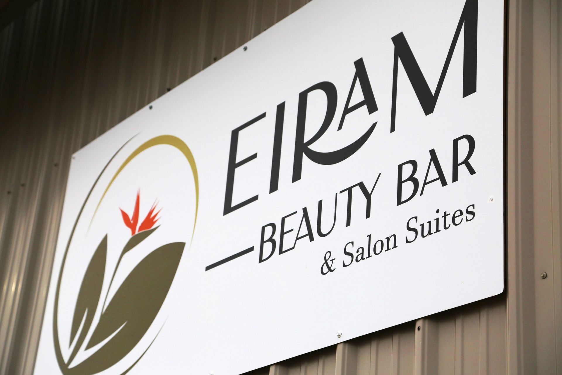 EIRAM Beauty Bar & Salon Suites sign on a wood-paneled exterior wall.