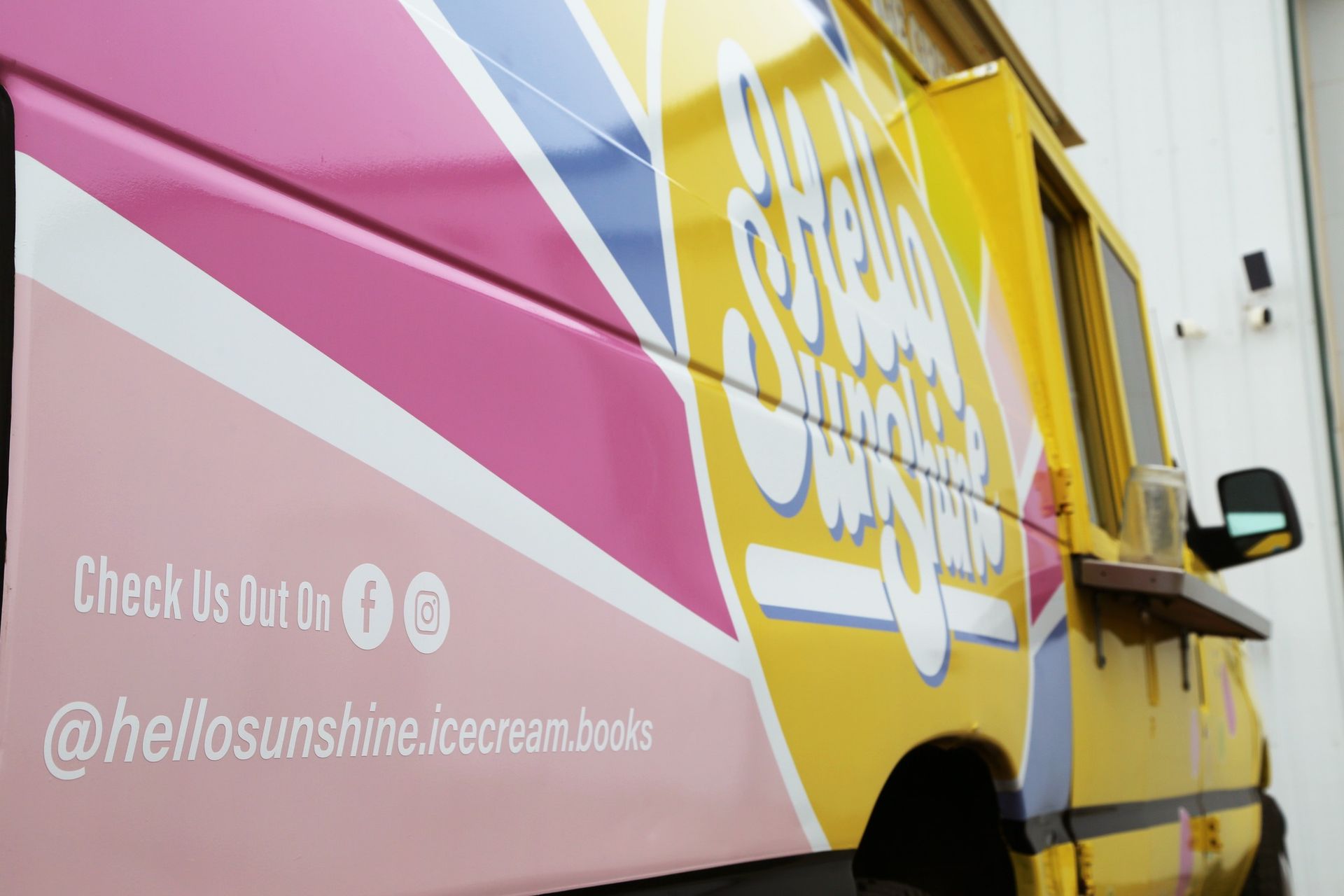 Bright pink and yellow Sunshine Ice Cream truck with “Check Us Out!” and @hellosunshineicecreamtools text