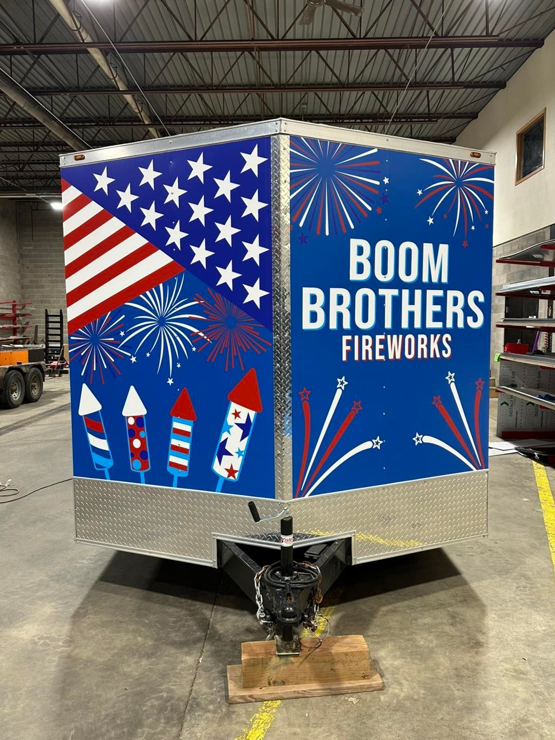 Boom Brothers Fireworks trailer with patriotic red, white, and blue graphics and rockets.