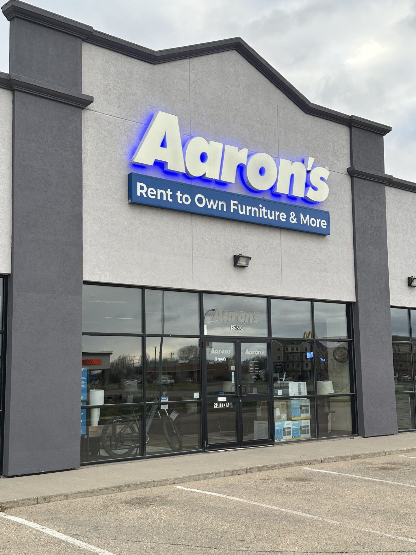 Aaron’s furniture and appliance store storefront with large blue sign and glass windows