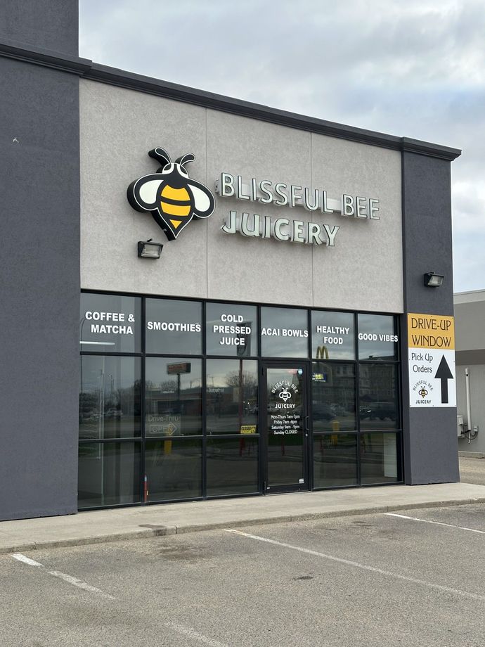 Exterior of BJ’s Restaurant & Brewhouse with storefront windows and parking lot under cloudy sky