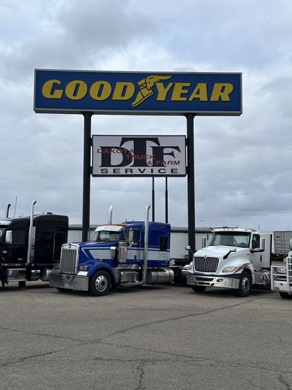 Goodyear sign above DAF Service lot with parked trucks and semi-trailers