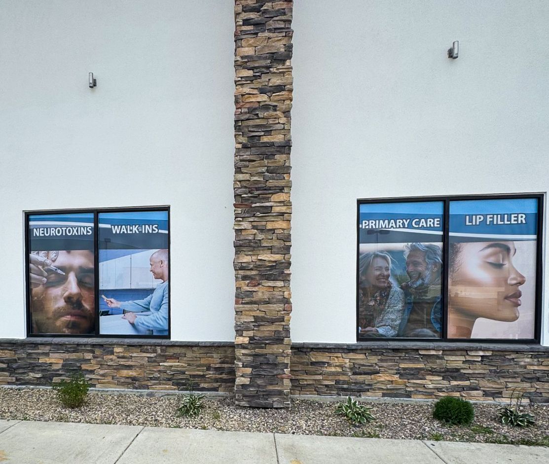 Storefront windows with health-care posters on a stone-and-white building façade