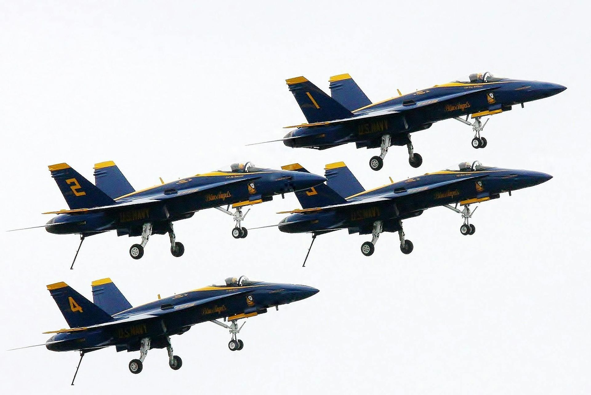 A group of fighter jets flying in formation with the number 4 on the tail