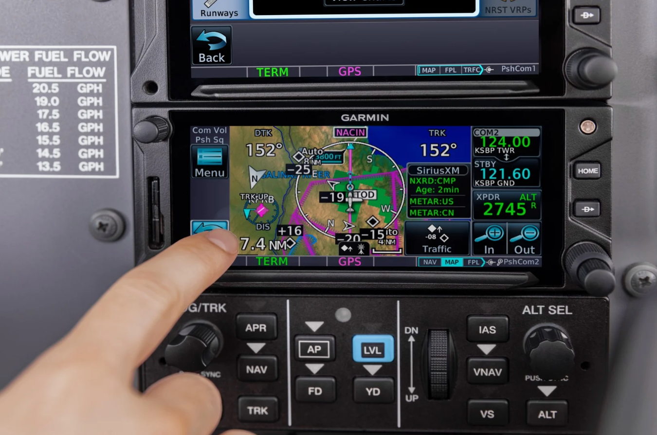 A person is pointing at a garmin gps aviation screen that says 152 on it