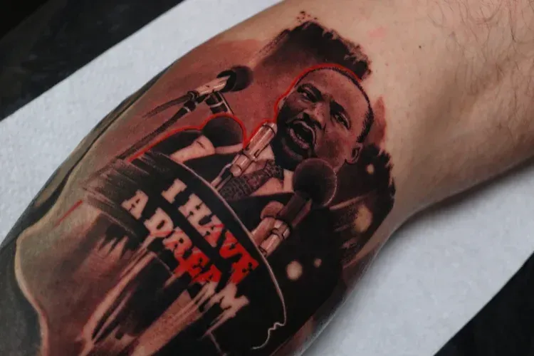 A tattoo of Martin Luther King Jr. speaking at a podium with the words