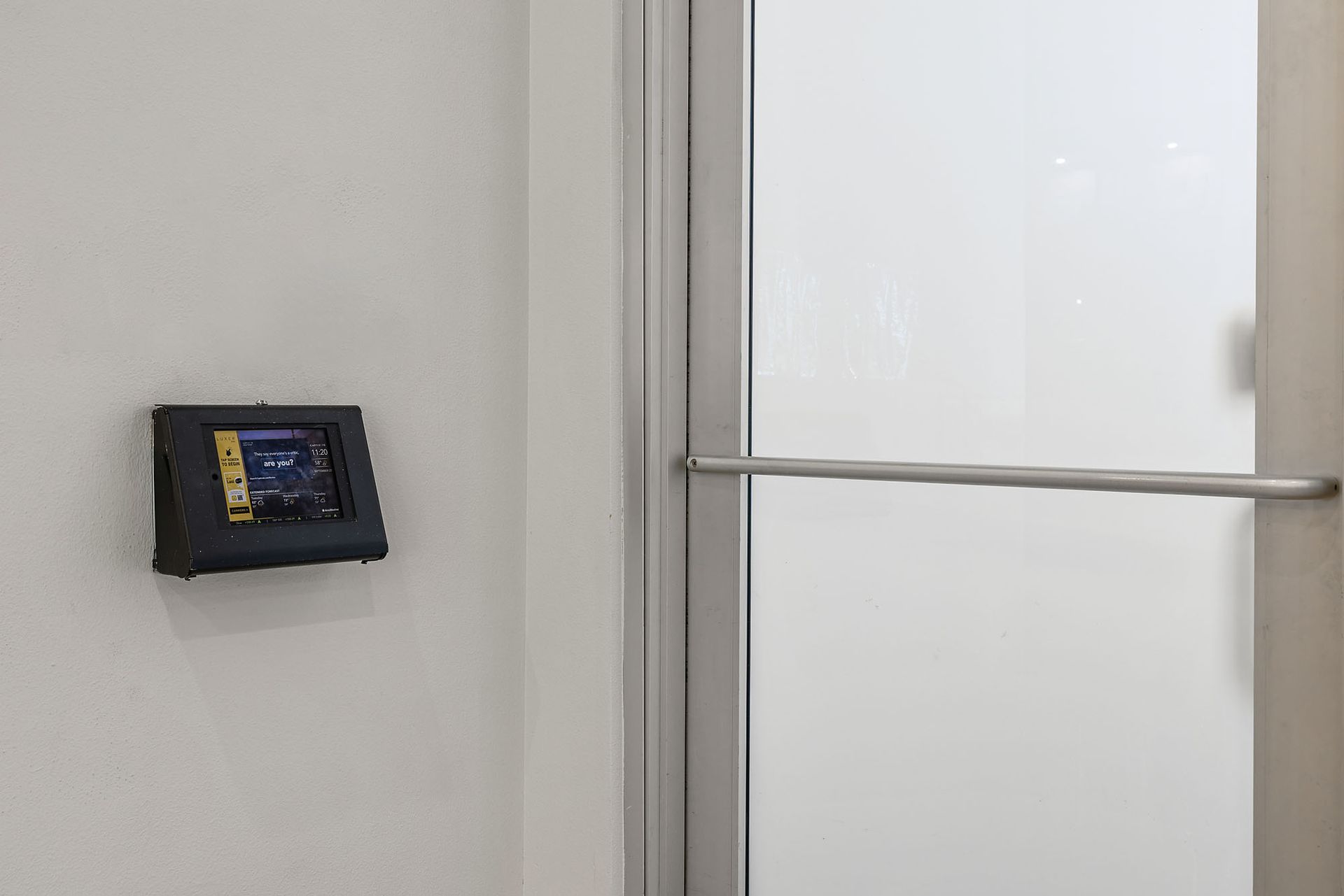Wall-mounted access control panel beside a frosted glass door at The Marq at Ridgegate in Lone Tree, CO.