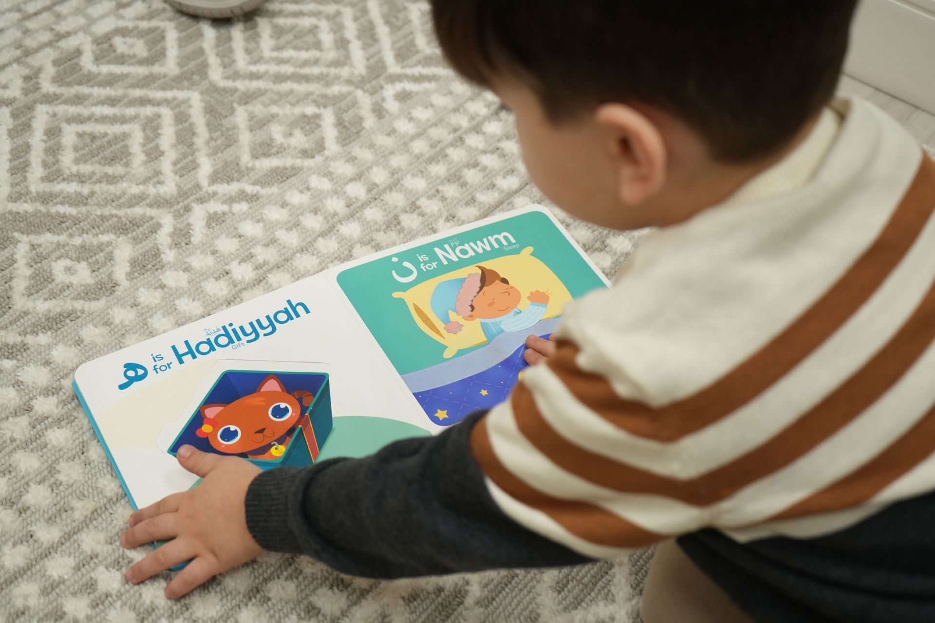 A young boy is sitting on the floor reading a book.