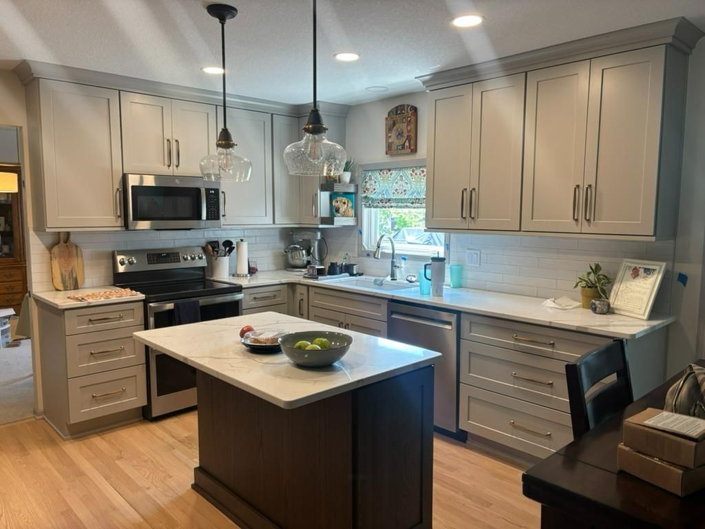 Modern kitchen with beige cabinets, stainless appliances, and an island with fruit bowl