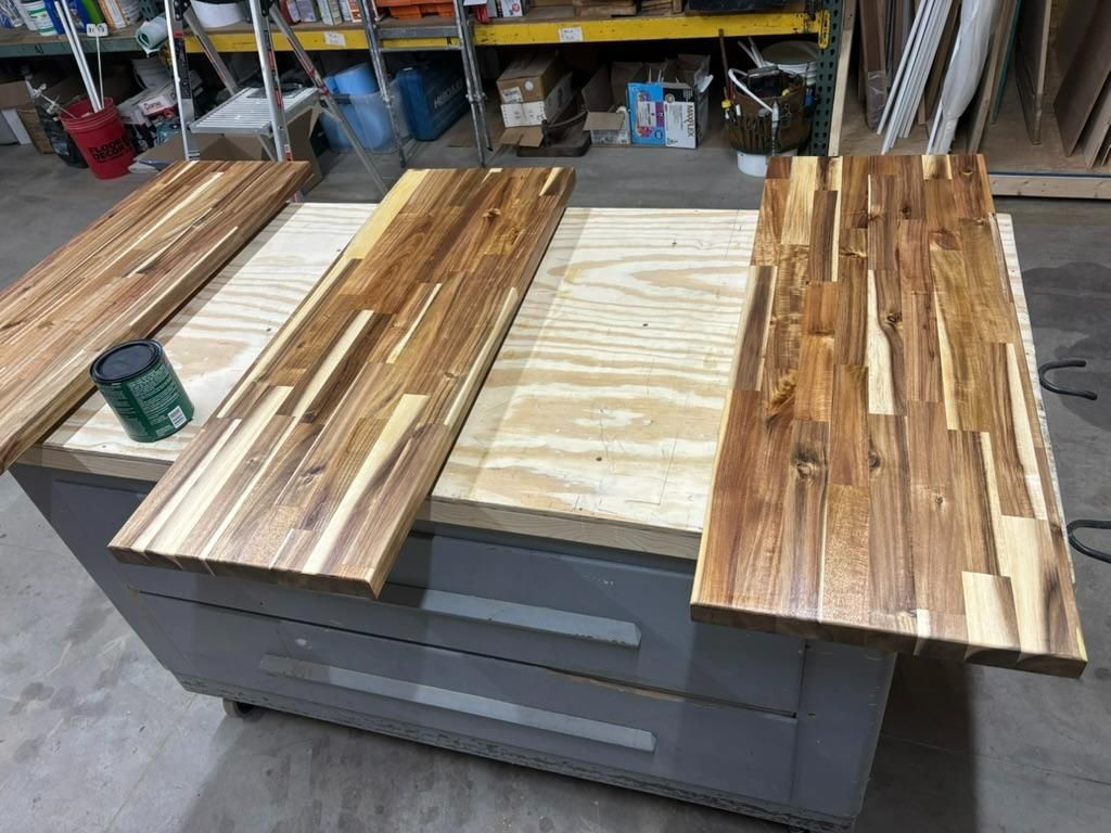 Wood slabs and strips laid out on a workshop cart, with a green cup on the left.