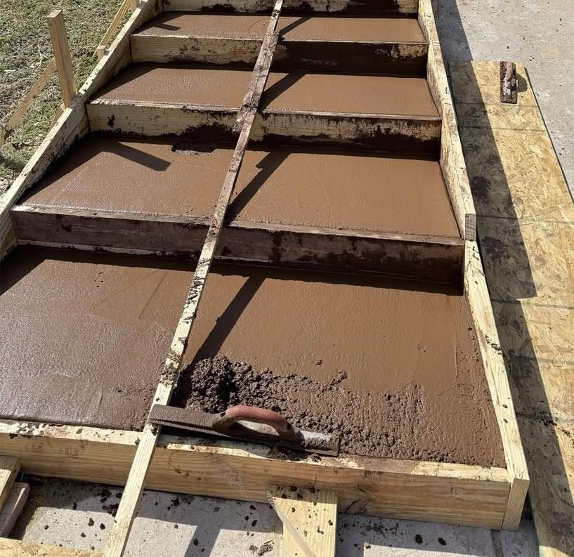 Freshly poured brown concrete steps in a wooden formwork mold outdoors
