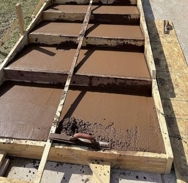 Freshly poured brown concrete steps in a wooden formwork mold outdoors