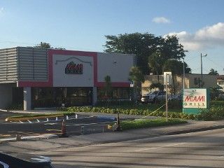 A fast food restaurant with a parking lot in front of it.