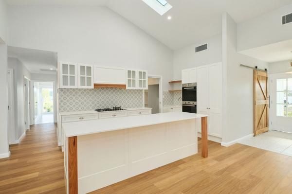 An Empty Kitchen with White Cabinets and Wooden Floors | Mid-North Coast, NSW | BDM Constructions