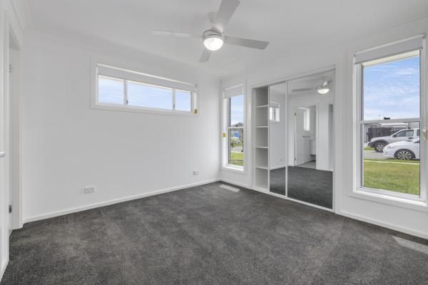 An Empty Bedroom with A Ceiling Fan and Sliding Glass Doors | Mid-North Coast, NSW | BDM Constructions