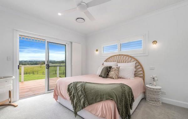 A Bedroom with A Large Bed and A Sliding Glass Door | Mid-North Coast, NSW | BDM Constructions